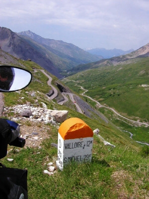 Motorrad vor Hinweis auf Vallore und Blick ins Tal