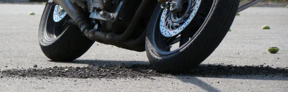 Überfahren von Dreck auf Teer in Schräglage Überfahren von Dreck auf Teer in Schräglage