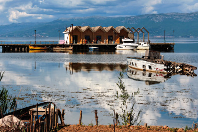 Hafen am Ohrid-See mit Booten vor Hütten.