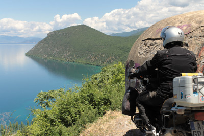 Motorradfahrer vor Hoxha Bunker mit Blick hinunter auf den Ohrid See.