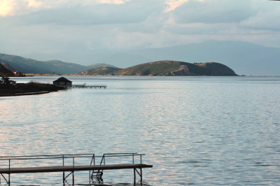 Weitblick auf den Ohrid-See mit Halbinsel und Steg im Vordergrund.