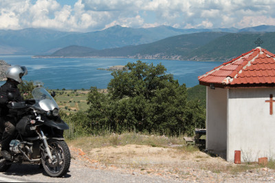 Motorradfahrer mit Blick zurück auf den großen Prespa-See.