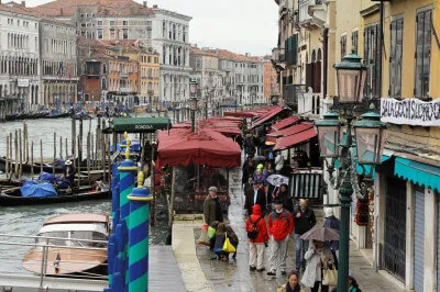 Uferpromenade mit Einkaufsläden und Gondeln Menschen auf Uferpromenade vor Einkaufsläden und Gondeln