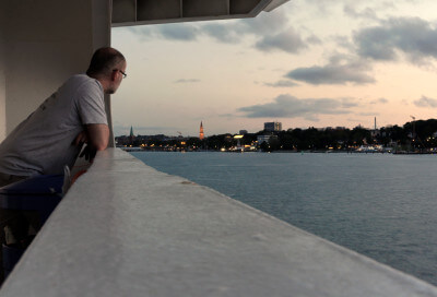 Mann auf Fähre mit Blick auf den Hafen von Kiel