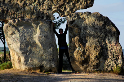 Frau steht zwischen zwei Steinblöcken am Strand von Kap Kolka