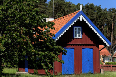 Braunes Holzhaus mit blauen Türen und Dachabschluß