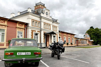 Auto und Motorrad parken vor dem Eingang des Bahnhofs in Haapsalu