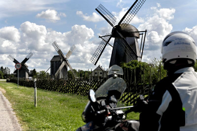 Motorrad steht vor den drei Windmühlen von Angla