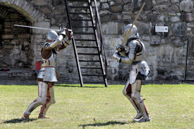 Zwei Ritter in voller Rüstung kämpfen mit Schwert beim Mittelalterfest