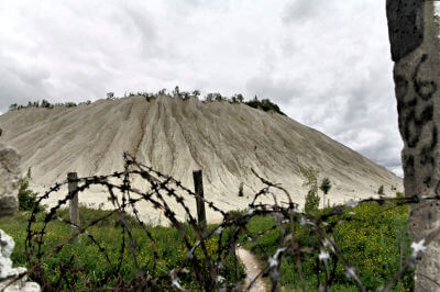 Stacheldrahtzaun vor einem Berg beim Gefängnis Rummu Quarry