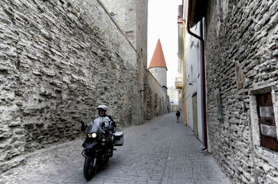 Motorrad fährt durch enge, kopfsteingepflasterte Gasse in der Altstadt von Tallin