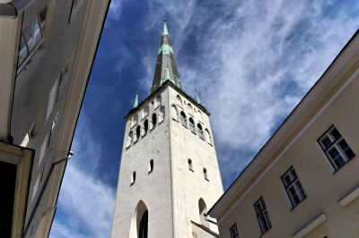 Hoch ragt der Turm der Olaikirche aus der Altstadt in den weiß blauen Himmel