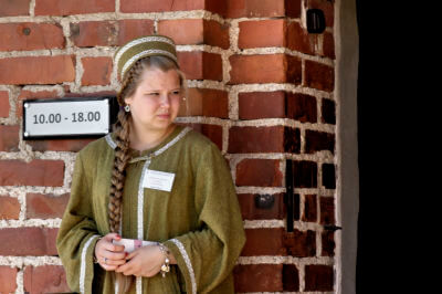 Mittelalterlich gekleidetes Mädchen steht an Türeingang