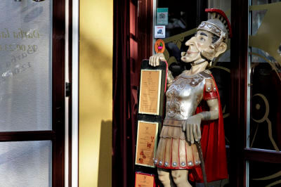 Figur eines Römers steht an einem Restaurant-Eingang