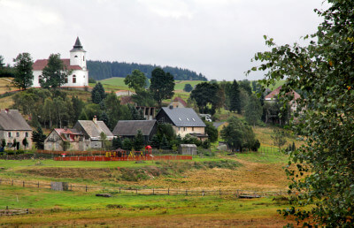 Landschaft und im Hintergrund ein Dorf mit Kirche