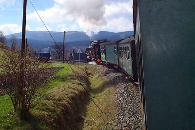 Blick aus fahrendem Zug nach vorne zur Dampflokomotive