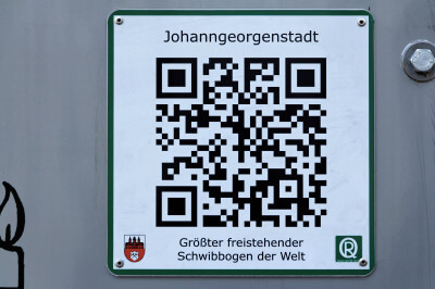 Hinweisschild mit der Aufschrift: Johanngeorgenstadt - größter freistehender Schwibbogen der Welt