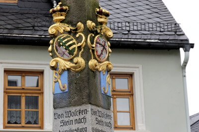 Wappen in Detailaufnahme der Postmeilensäule in Wolkenstein
