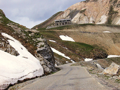 Straße mit Schneeresten und oberhalb liegender Militäranlage
