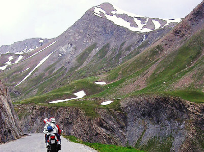 Auffahrt zum schneebedeckten Col du Galibier mit Motorradfahrer