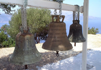 Drei Glocken hängen hintereinander an einem Holzgestell in der antiken Stadt Sami