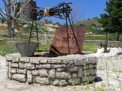 Ziehbrunnen mit Eimer am Seil und Blechklappe zum Verschließen