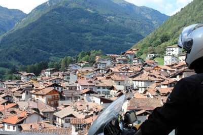 Motorradfahrer blickt auf die Dächer von Bagolino
