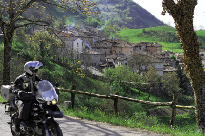 Motorrad macht Pause und Bergdörfer im Hintergrund am Idrosee