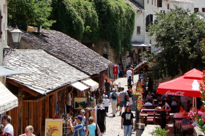 Ladenzeile in der Altstadt mit gedeckten Holzhütten und Touristen