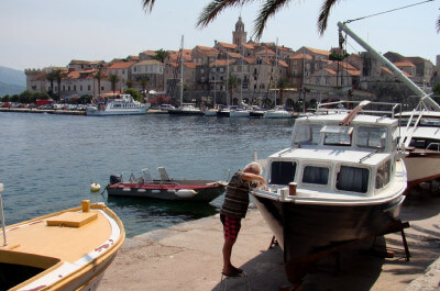 Blick auf ein Boot und im Hintergrund liegt Korčula