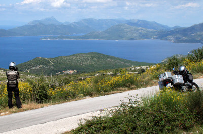 Panoramablick mit Motorrad, Bergen und blauem Meer