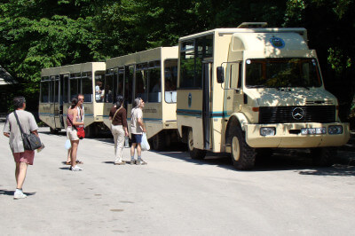 Ein parkender Touristenbus mit einsteigenden Touristen an den Plitvicer Seen