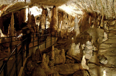 Stalagmiten und Stalagtiten rechts von einem Weg für die Touristen in der Höhle