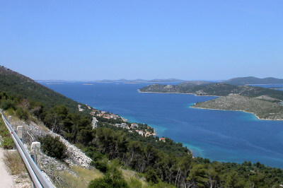 Panoramablick auf das blaue Meer und steil abfallendes grün bewachsenes Gelände