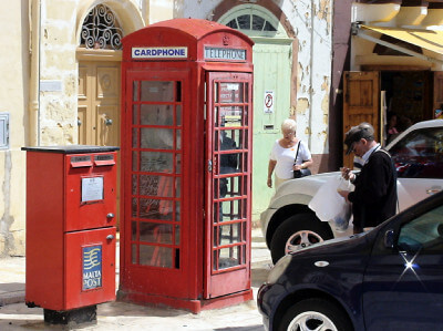 Rote englische Telefonzelle mit Postkasten daneben in Valletta