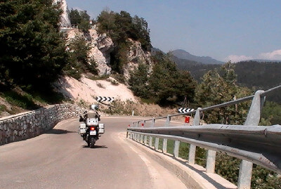 Motorradfahrer fährt auf Serpentine zu am Brezer Joch