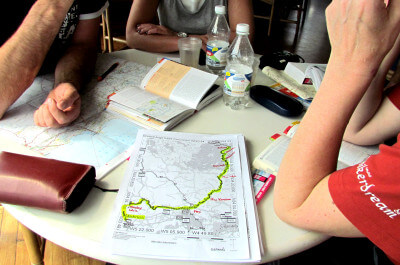 Vier Personen sitzen um eine Landkarte bei der Tourplanung auf der Fähre