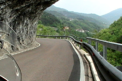 Straße mit Leitplanke und überhängenden Felsen auf dem Valli di Pasubio