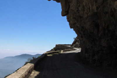 Abenteuerliche Straße mit kleiner Randbefestigung durch überhängende Felsen
