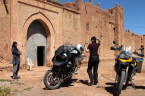 Zwei Motorräder und zwei Frauen stehen vor dem Eingang zur Kasbah Tamdakht