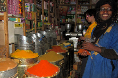 Händler in einem Gewürzladen mit bunten Gewürzen im Souk von Quarzazate