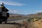 Motorrad steht auf einer langen geraden im Hohen Atlas