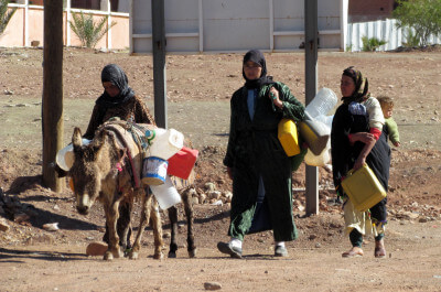 Familie mit Esel läuft am Straßenrand in Tinerhir