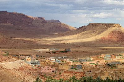 Panoramablick über ein Tal mit Häusern aus Lehm und Berge im Hintergrudn bei Tinerhir