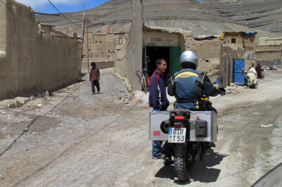 Motorrad steht vor Gabelung in die Gassen von Agoudal mit Berbern