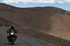 Hinterher fahrender Motorradfahrer in gebirgiger kahler Landschaft in Asif Melloul