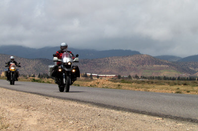 Zwei Motorräder fahren auf Straße im Mittleren Atlas Richtung Midelt
