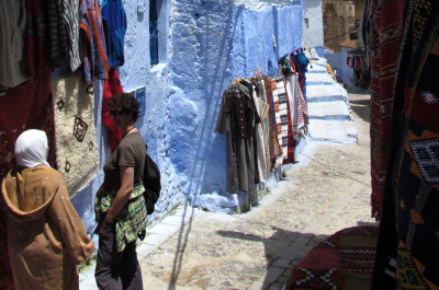 Gasse in Chefchaouen in blau gestrichene Häuser und zwei Marokaner im Gespräch vertieft