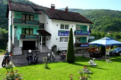 Im Motel Bavaria finden wir alles, was wir benötigen: Dach über'm Kopf, traditionelle Küche und einen Parkplatz. Blick auf das Haus des Motel Bavaria Foča mit vorgelagerter grünen Wiese