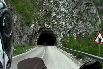 Mit Sonnenbrille aus dem Hellen kommend, hast du das Gefühl von einem schwarzen Loch verschlungen zu werden, wäre da nicht rettendes Licht am Ende des meist nicht allzu langen Tunnels am Piva-Stausee. Unbeleuchteter Tunnel am Pivastausee